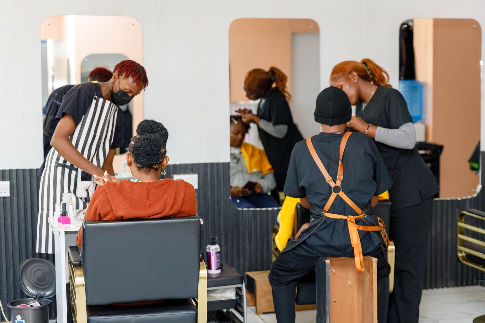 Two stylists working on client locs